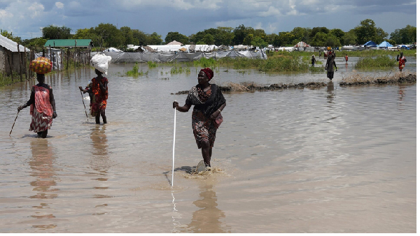 Women wade through flood waters after the River Nile broke the dykes in Pibor