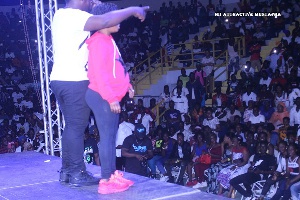Nii Funny on stage with the pregnant woman