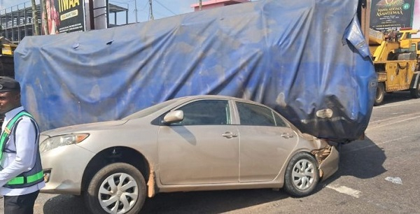 A picture from the accident scene shows a truck covered with blue tarpaulin and a saloon car