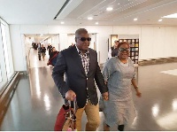 Former President John Dramani Mahama carrying his wife's bag