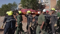A rescue team carries the body of an earthquake victim