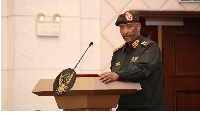 Sudan's military leader General Abdel Fattah al-Burhan stands at the podium during a ceremony