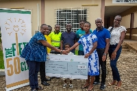 One of the beneficiaries being represented with a cheque