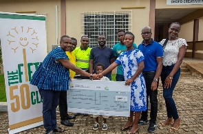 One of the beneficiaries being represented with a cheque