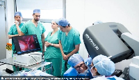 Surgeons look at a screen displaying an AI overlay of patient anatomy during the operation