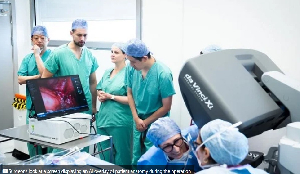 Surgeons look at a screen displaying an AI overlay of patient anatomy during the operation