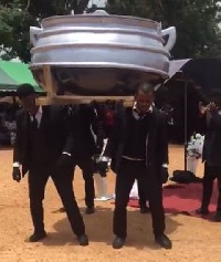 Pallbearers dancing with the cooking pot coffin