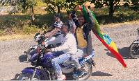A motorcycle passenger holds up an Ethiopian flag to welcome former Tigray leader Getachew Reda