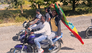 A motorcycle passenger holds up an Ethiopian flag to welcome former Tigray leader Getachew Reda
