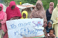 Sudanese refugees hold a sign that calls for protection in Ethiopia