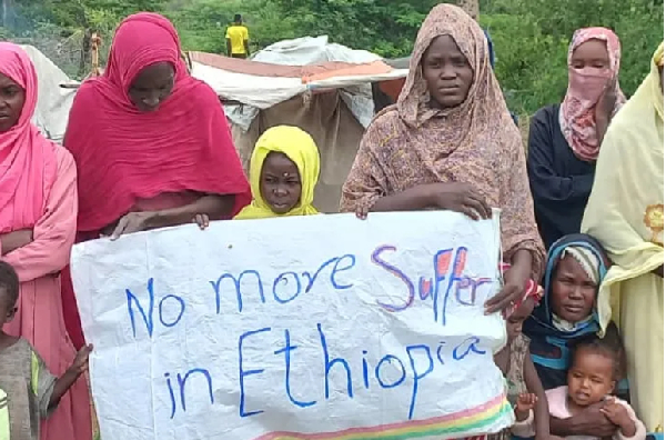 Sudanese refugees hold a sign that calls for protection in Ethiopia