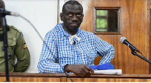 Veteran Ugandan opposition leader Kizza Besigye stands in the dock at the courtroom