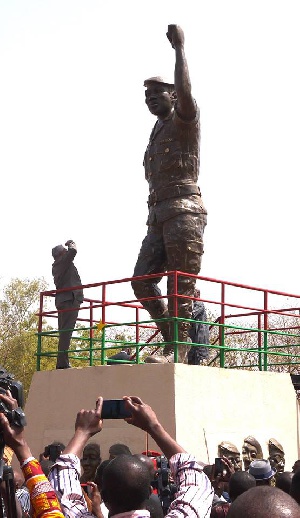 JJ Rawlings standing in front of Thomas Sankara statue