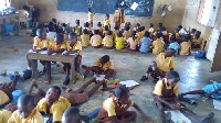 More than one class shares same classroom with pupils having no desks to sit on
