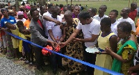 Representative of Project Maji with Chief of the Area cutting the tape to open the facility.