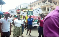 Placard bearing health works and breast cancer survivors in a float on the street of Koforidua