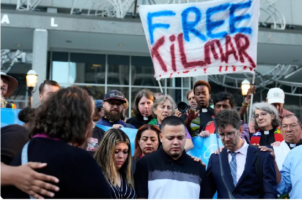 Kilmar Abrego Garcia, centre, is flanked by his lawyer and wife at a protest
