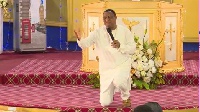 Sam Korankye Ankrah kneeling in front of his congregation apologising to the Chief Imam and others