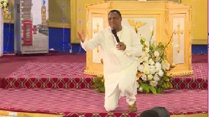 Sam Korankye Ankrah kneeling in front of his congregation apologising to the Chief Imam and others