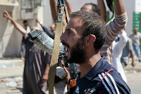 A Libyan rebel fighter in Zawiya reacts to news of Surman's capture