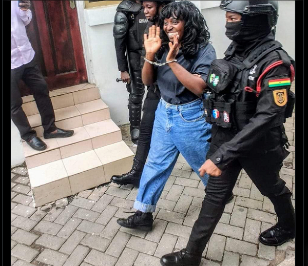 Felicity Nelson in hand cuffs and surrounded by some police guards