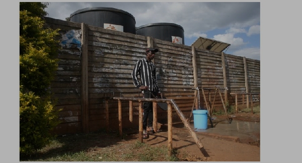 A man uses a bucket to collect safe drinking water for his family in Kuwadzana township