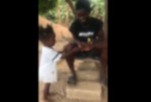 The video shows the adult men giving a cigarette to the child