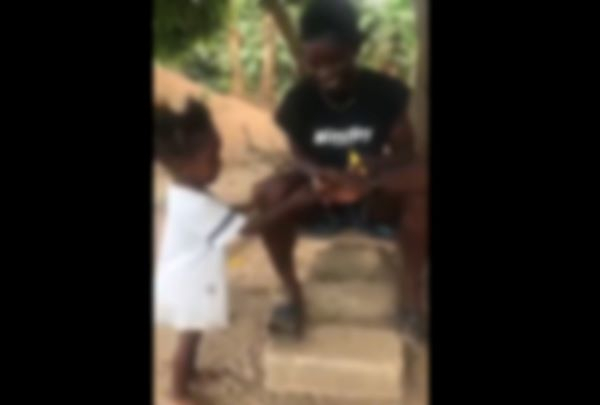 The video shows the adult men giving a cigarette to the child
