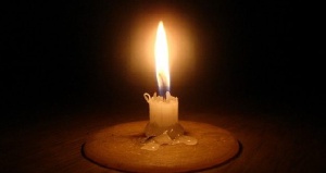 Lighted candle in darkness.    File photo.
