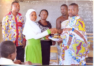 A pupil of the Islamic School receiving some of the items from Nana Kwanfo II