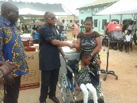 Simon Osei-Mensah presenting wheelchair some persons with disability