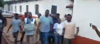 John Dumelo walking side-by-side with the Electoral Officer