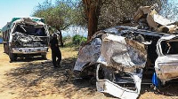 A man views the wreckage of a 14-seater minibus that was involved in an accident killing