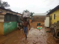 A man carries some of his salvaged properties to safety