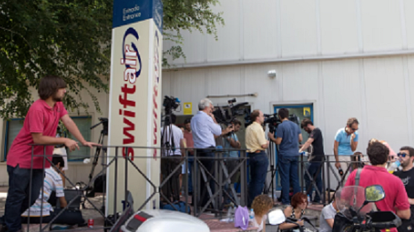 Journalists wait for news outside the Spanish Swiftair airline office in Madrid