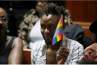 An LGBTQ activist holds a rainbow flag during a court hearing in the Milimani High Court in Nairobi