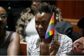 An LGBTQ activist holds a rainbow flag during a court hearing in the Milimani High Court in Nairobi