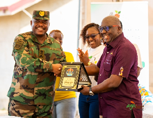 Daniel Fahene Acquaye presenting a plague to Lieutenant General William Agyapong