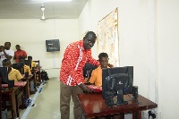 Samuel Gyimah, National Distribution Manager - Airtel Ghana, with a student