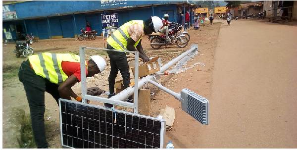 Employees of Geses U Ltd fitting solar street lighting units along the Kabale garage street