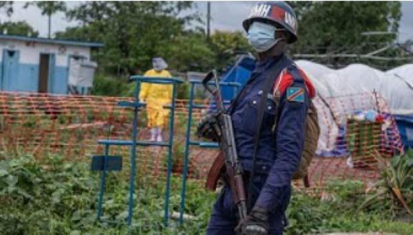 A Congolese police officer guards the Ebola treatment centre after the facility was burned down
