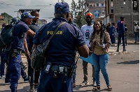 Congolese police talk to demonstrators calling on authorities to enforce an agreed withdrawal of M23