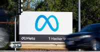 A car passes by Facebook's new Meta logo on a sign at the company headquarters