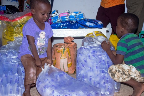 An orphan helping with the packing of donated items