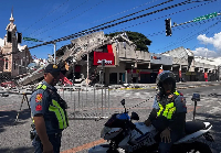 Police gather in front of a collapsed a fast food restaurant after an 7.8 magnitude earthquake