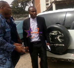 Suspect, Anthony Ayenme (in suit) with a police officer