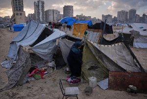 Iman Al-Atoutt repairs her tent after days of rain in a makeshift camp for displaced Palestinians