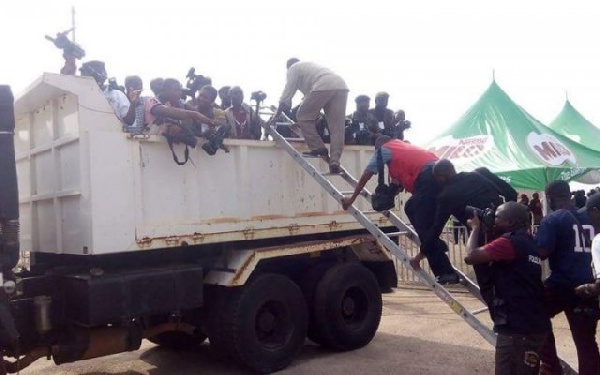 Some Journalists packed in a bucket of the truck