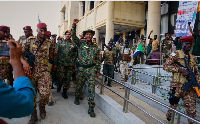 Sudan's military chief Abdel Fattah al-Burhan, (C), is greeted by soldiers