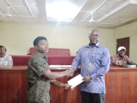 The MP (right) giving an envelope to one of the students he supported